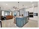 Open-concept kitchen with a large island, stainless steel appliances, and views to living area with leather sofas at 3005 Crispin Cir, Harmony, FL 34773