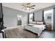 Main bedroom features a ceiling fan, hardwood floors, ensuite bathroom, and two bright windows at 3005 Crispin Cir, Harmony, FL 34773