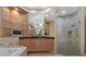 Luxurious bathroom with double vanity, glass shelving, soaking tub, and a glass-enclosed shower at 304 Acadia Ln, Celebration, FL 34747
