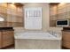 Bright bathroom featuring a tub with marble surround, a window with plantation shutters, and custom cabinetry at 304 Acadia Ln, Celebration, FL 34747