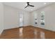 Light-filled bedroom with hardwood floors, three arched windows with plantation shutters, and a ceiling fan at 304 Acadia Ln, Celebration, FL 34747