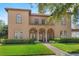Stunning Mediterranean-style home with a tile roof, arched windows, and a beautifully landscaped front yard with a brick walkway at 304 Acadia Ln, Celebration, FL 34747