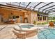 Outdoor hot tub features a tiled exterior, alongside a covered outdoor kitchen, and spacious patio area at 304 Acadia Ln, Celebration, FL 34747