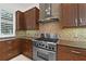 Modern kitchen with stainless steel range hood and range, and wood cabinets at 304 Acadia Ln, Celebration, FL 34747