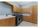 Laundry room with ample cabinet space, sink, and modern washer and dryer at 304 Acadia Ln, Celebration, FL 34747