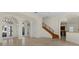 Elegant living room with tile flooring, archways, staircase, and multiple windows and glass doors at 304 Acadia Ln, Celebration, FL 34747