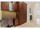 Built-in office space with desk, cabinets, and mosaic tile backsplash in this home at 304 Acadia Ln, Celebration, FL 34747