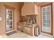 Outdoor kitchen includes a stainless steel grill, sink, storage, and trash can, surrounded by tiled flooring at 304 Acadia Ln, Celebration, FL 34747