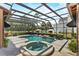 Sparkling pool and hot tub with screened enclosure, creating a serene backyard retreat at 304 Acadia Ln, Celebration, FL 34747