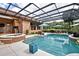Relaxing pool area with screened enclosure, a spa, and an outdoor kitchen, ideal for entertaining guests at 304 Acadia Ln, Celebration, FL 34747