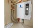 The ecosmart tankless water heater is wall-mounted with pipe and valve connections, and electronic controls at 304 Acadia Ln, Celebration, FL 34747