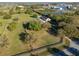Aerial view of property with home, detached garage, mature trees, and green pastures at 3161 Appaloosa Ct, Kissimmee, FL 34746