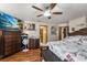 Spacious bedroom featuring wood floors, a ceiling fan and an entertainment center at 3161 Appaloosa Ct, Kissimmee, FL 34746