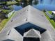 Aerial view of the home's roof and surrounding property, including a pond, fence and green grass at 3874 Blackberry Cir, St Cloud, FL 34769