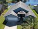 Aerial view of blue home with well-manicured lawn, white fence, and a serene lake view, showcasing curb appeal at 3874 Blackberry Cir, St Cloud, FL 34769