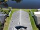Aerial view of the home's roof and surrounding property, including a pond, fence and green grass at 3874 Blackberry Cir, St Cloud, FL 34769