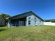 Expansive backyard of this blue home, features well manicured lawn, screened in patio and white fencing at 3874 Blackberry Cir, St Cloud, FL 34769