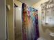 The bathroom features a shower with colorful curtains and tiled walls, next to a window with patterned curtains at 3874 Blackberry Cir, St Cloud, FL 34769