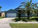 Charming single-story home with a blue facade, complemented by a mature palm tree in the front yard at 3874 Blackberry Cir, St Cloud, FL 34769