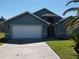 Charming home exterior with a two car garage, well maintained lawn and mature palm trees at 3874 Blackberry Cir, St Cloud, FL 34769