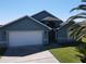 Charming home exterior with a two car garage, well maintained lawn and mature palm trees at 3874 Blackberry Cir, St Cloud, FL 34769