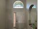 Bright foyer with a transom window above the door, an arched mirror, and neutral paint at 3874 Blackberry Cir, St Cloud, FL 34769