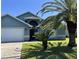 Exterior shows the home and garage with a front lawn and tropical palm trees at 3874 Blackberry Cir, St Cloud, FL 34769