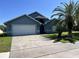 Exterior front view of the home showing garage and front lawn on a sunny day at 3874 Blackberry Cir, St Cloud, FL 34769