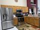 Well-equipped kitchen with stainless steel appliances, wood cabinets, and stylish tile flooring at 3874 Blackberry Cir, St Cloud, FL 34769