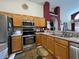Bright kitchen featuring stainless steel appliances, wood cabinetry, and laminate countertops at 3874 Blackberry Cir, St Cloud, FL 34769