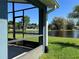 Patio view showcasing lush greenery, a serene pond, and neighboring houses under a clear, blue sky at 3874 Blackberry Cir, St Cloud, FL 34769