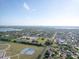 Aerial view of a community with a lake, schools, and residential area under a bright blue sky at 4548 Cepeda St, Orlando, FL 32811