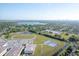 Aerial view of a school complex, lake, and residential area under a bright blue sky at 4548 Cepeda St, Orlando, FL 32811