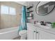 Bathroom featuring a shower-tub combo, vanity with sink, mirror and shelving at 4548 Cepeda St, Orlando, FL 32811