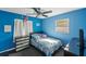 Cozy bedroom with vibrant blue walls, ceiling fan, and a comfortable bed at 4548 Cepeda St, Orlando, FL 32811