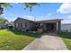 Charming gray single-story home with red trim and an attached carport on a sunny day at 4548 Cepeda St, Orlando, FL 32811