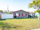 Well-kept single Gathering home with gray siding, red trim, a well-manicured lawn, and a white privacy fence at 4548 Cepeda St, Orlando, FL 32811