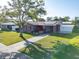 Charming gray home with red trim, solar panels, covered entrance, and a well-maintained front yard at 4548 Cepeda St, Orlando, FL 32811