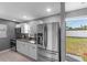 Modern kitchen with stainless steel fridge, granite countertops, white cabinets, and mosaic backsplash at 4548 Cepeda St, Orlando, FL 32811