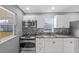 Modern kitchen featuring stainless steel appliances, granite countertops, white cabinets and mosaic backsplash at 4548 Cepeda St, Orlando, FL 32811