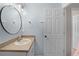 Neat bathroom with a round mirror over a clean sink, white cabinets, and neutral wall paint at 4743 Vero Beach Pl, Kissimmee, FL 34746
