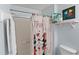 Well-lit bathroom with a shower showcasing a stylish curtain, and a clean white toilet at 4743 Vero Beach Pl, Kissimmee, FL 34746