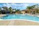 Large community swimming pool with lounge chairs and tropical landscaping at 4743 Vero Beach Pl, Kissimmee, FL 34746