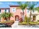 Townhouse front with colorful landscaping, palm trees, and sunny curb appeal at 4743 Vero Beach Pl, Kissimmee, FL 34746