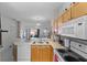 Well-lit kitchen with wooden cabinets, modern appliances, and an open layout to the living area at 4743 Vero Beach Pl, Kissimmee, FL 34746