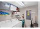 Functional laundry room with washer, dryer, and overhead storage shelves at 4743 Vero Beach Pl, Kissimmee, FL 34746