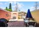 Inviting patio with red brick floor, outdoor seating, a grill, and a blue umbrella for shade at 4743 Vero Beach Pl, Kissimmee, FL 34746