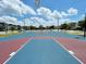 Outdoor basketball court with a colorful surface, lighting, and well-maintained surroundings at 481 Ocean Course Ave, Davenport, FL 33896