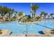 Large community pool area with a waterslide, lush landscaping, and palm trees at 481 Ocean Course Ave, Davenport, FL 33896