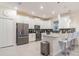 Modern kitchen with stainless steel appliances, white cabinetry and counter seating at 481 Ocean Course Ave, Davenport, FL 33896